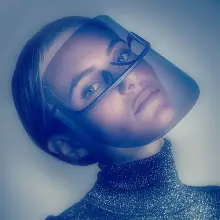 Una donna con la testa leggermente inclinata indossa uno scudo facciale